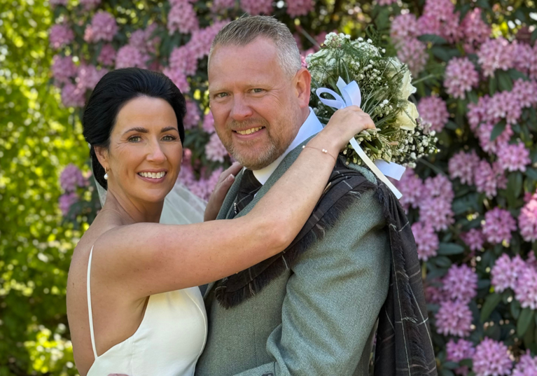 Wedding couple smiling at camera by Let's Do It Creative